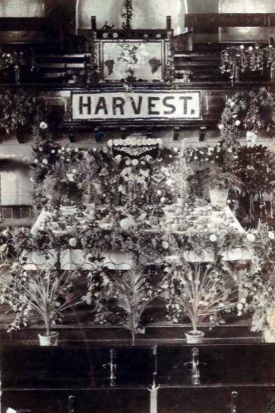 Rows of flowers and other gifts rising up to the pulpit in a display